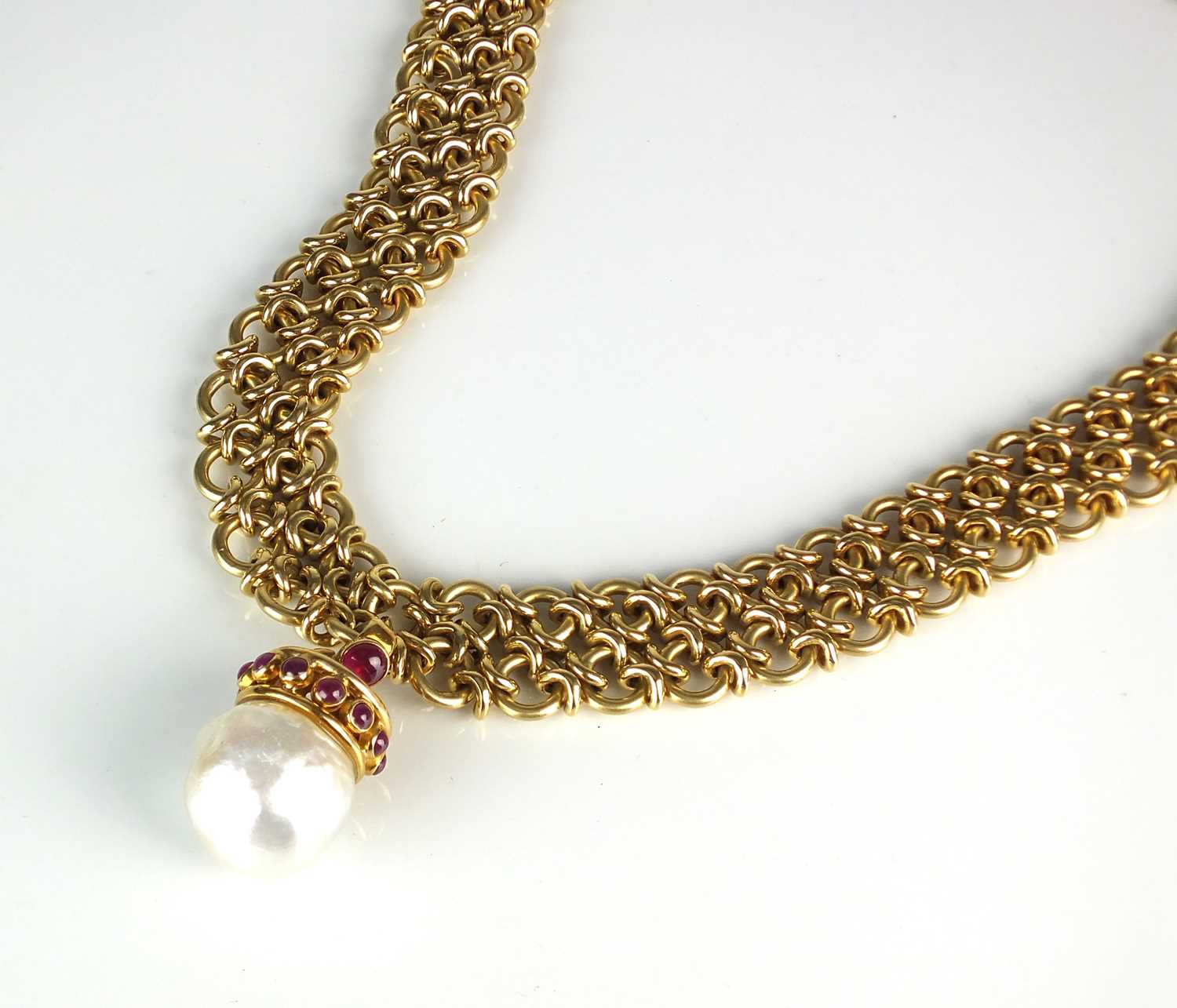 78 - An 18ct gold necklace with baroque cultured pearl and ruby pendant