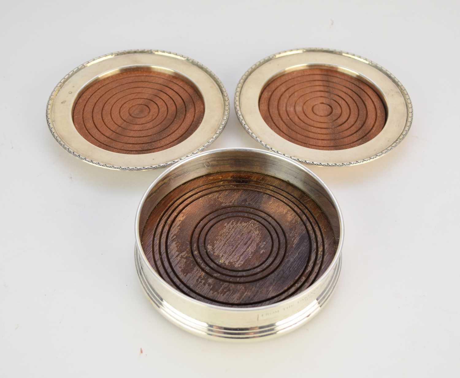 Lot 111 - A pair of silver mounted coasters and a silver mounted wine coaster
