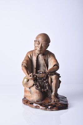 Lot 87 - A Chinese Shiwan figure of a seated man, Qing Dynasty