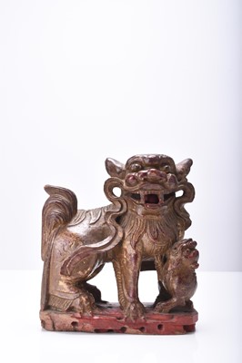 Lot 117 - A Chinese carved and painted wood figure of a guardian lion, Qing Dynasty