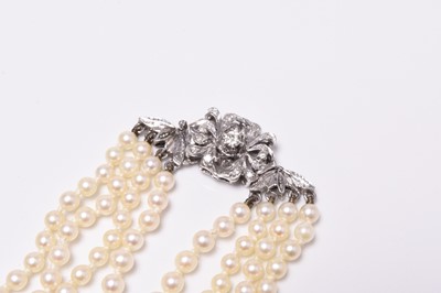 Lot 345 - A four strand graduated cultured pearl necklace with 18ct white gold diamond set clasp