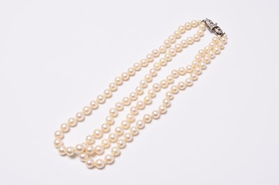 Lot 399 - A two strand uniform cultured pearl necklace with diamond set clasp