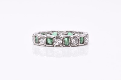 Lot 27 - An emerald and diamond eternity ring