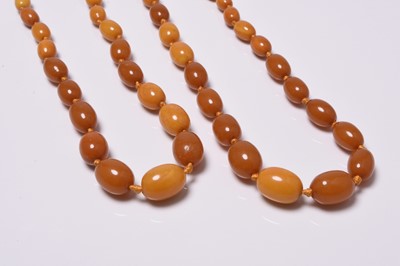 Lot 200 - Two graduated oval amber bead necklaces