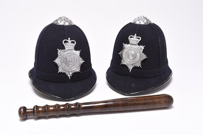 Lot 83 - Two police helmets and a truncheon