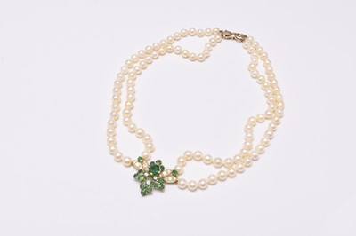 Lot 37 - A two strand cultured pearl necklace with emerald and diamond set pendant