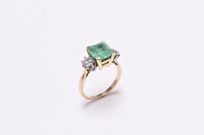 Lot 56 - A three stone emerald and diamond ring