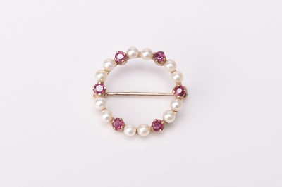 Lot 142 - A 9ct gold ruby and seed pearl set circular brooch