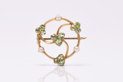 Lot 56 - A circular split pearl and green stone openwork brooch