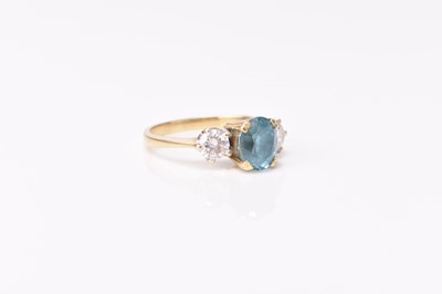 Lot 253 - An 18ct gold three stone blue zircon and diamond ring