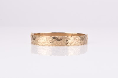 Lot 145 - A 9ct gold bright cut engraved hinged bangle