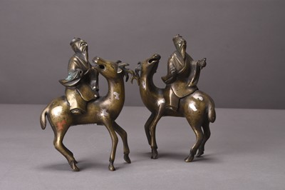 Lot 94 - Two Chinese silver-inlaid bronze figures of lohan riding deer