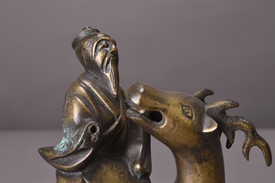 Lot 94 - Two Chinese silver-inlaid bronze figures of lohan riding deer