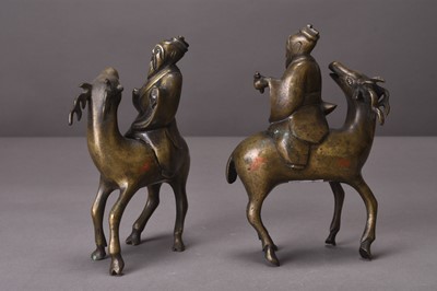 Lot 94 - Two Chinese silver-inlaid bronze figures of lohan riding deer