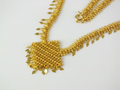 Lot 61 - A yellow metal decorative bead and tassel necklace