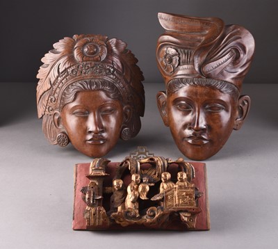 Lot 253 - A pair of Balinese carved wood wall masks and a South East Asian altar fragment