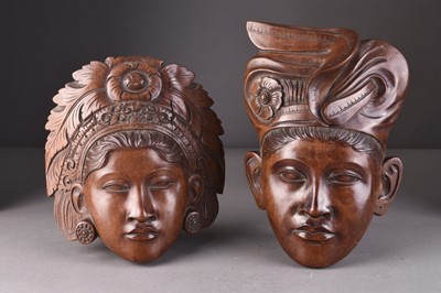 Lot 253 - A pair of Balinese carved wood wall masks and a South East Asian altar fragment