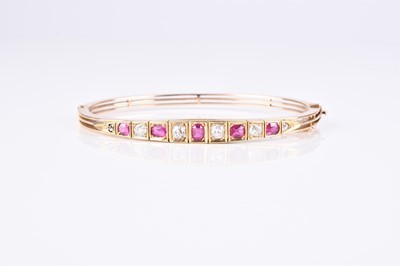 Lot 132 - An early 20th century diamond and ruby set hinged bangle