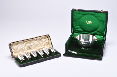 Lot 96 - An Edwardian cased set of six silver tot cups and a cased silver bowl and spoon