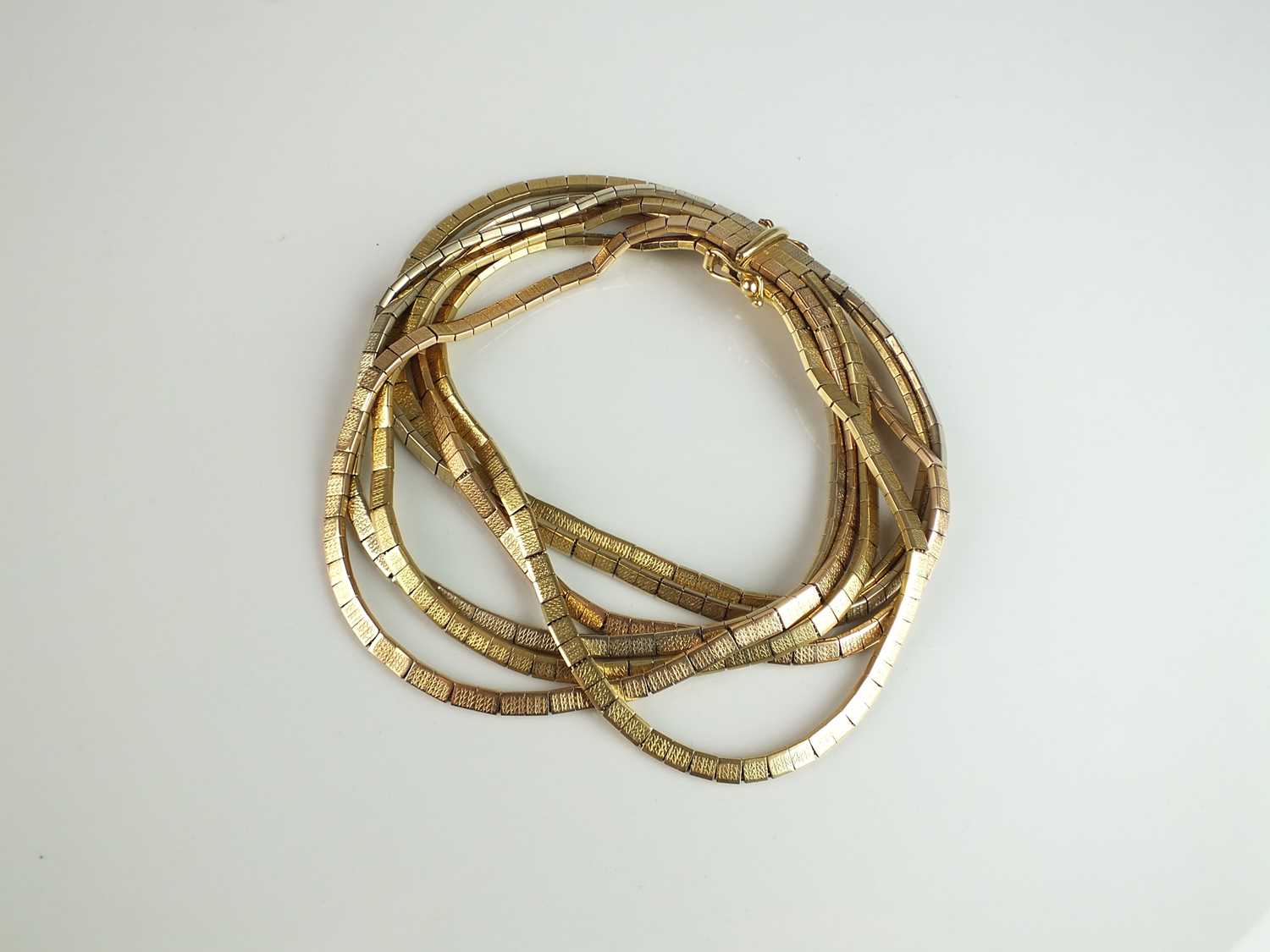 Lot 270 - A yellow, white and rose metal multi-strand bracelet