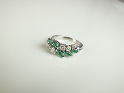 Lot 162 - A diamond and emerald stylised crossover ring