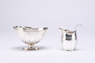 Lot 98 - A George III silver helmet cream jug and a Victorian silver sugar basket