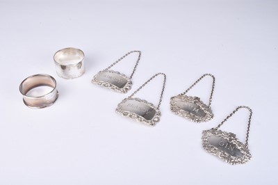 Lot 112 - Four silver decanter labels and two silver napkin rings