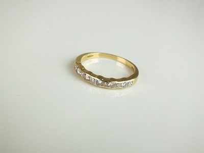 Lot 184 - An 18ct gold eleven stone diamond set half eternity ring