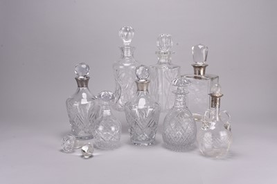 Lot 33 - Eight cut and plain glass decanters, including four with silver collars