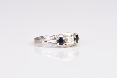 Lot 134 - A graduated three stone diamond and sapphire ring