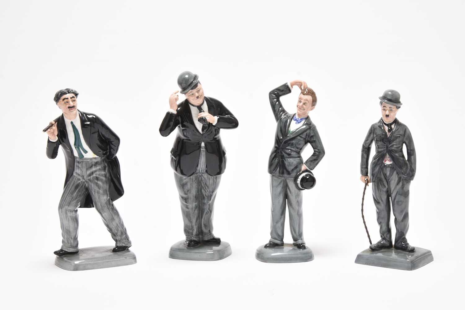 Lot 177 - Four Royal Doulton figures - Oliver Hardy, Groucho Mark, Stan Laurel, Charlie Chaplin