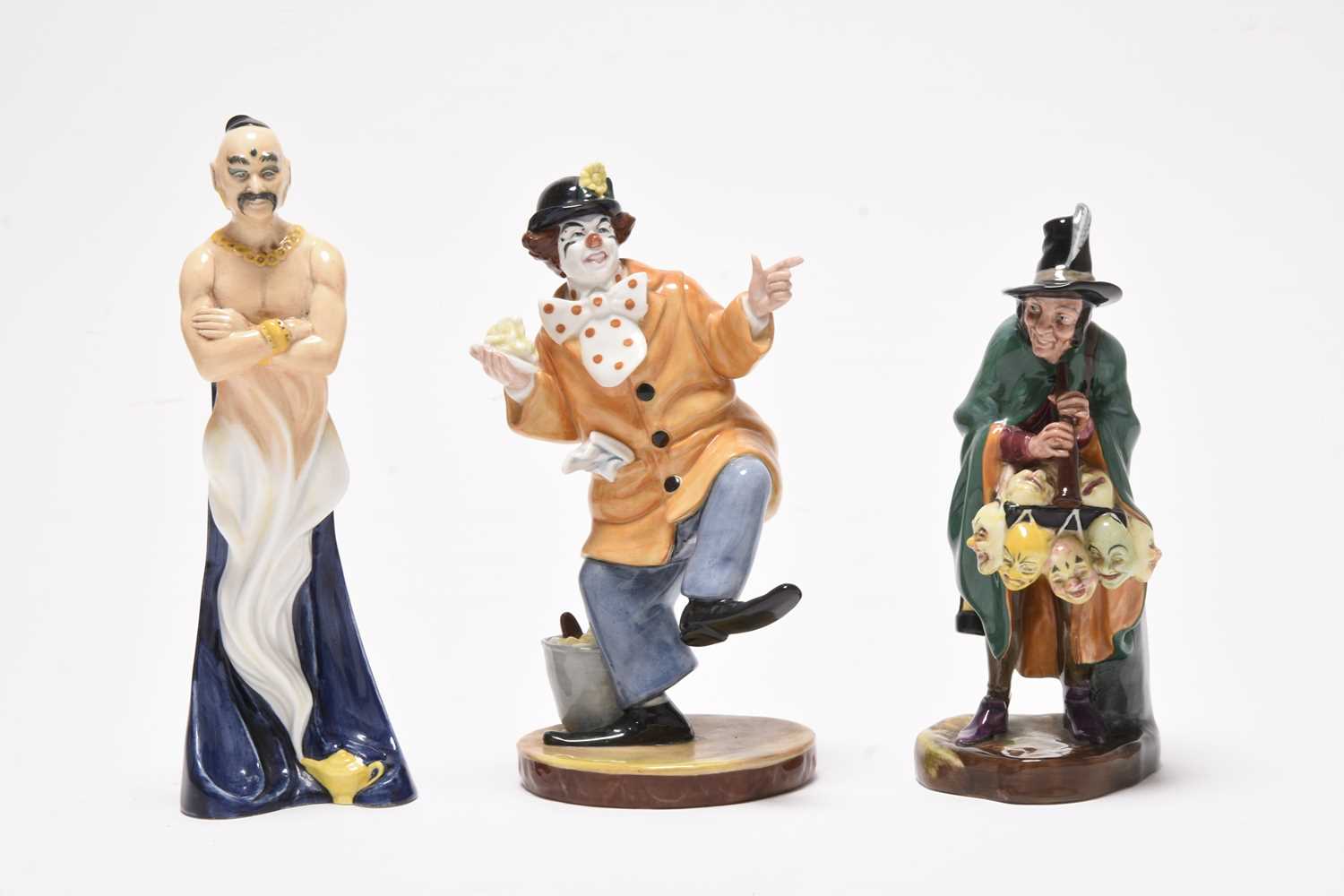 Lot 162 - Three Royal Doulton figures including 'Mask Seller' HN2103 and a group of monk figures