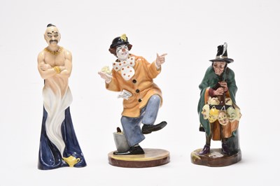 Lot 162 - Three Royal Doulton figures including 'Mask Seller' HN2103 and a group of monk figures