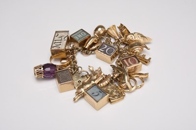 Lot A 9ct gold charm bracelet with attached charms