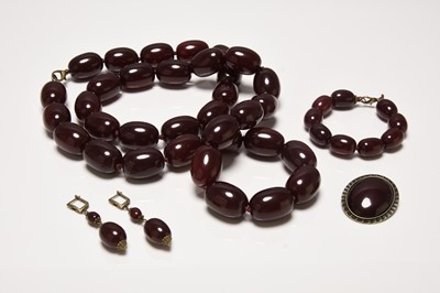 Lot 349 - A uniform cherry red amber style necklace, with bracelet, earrings and brooch