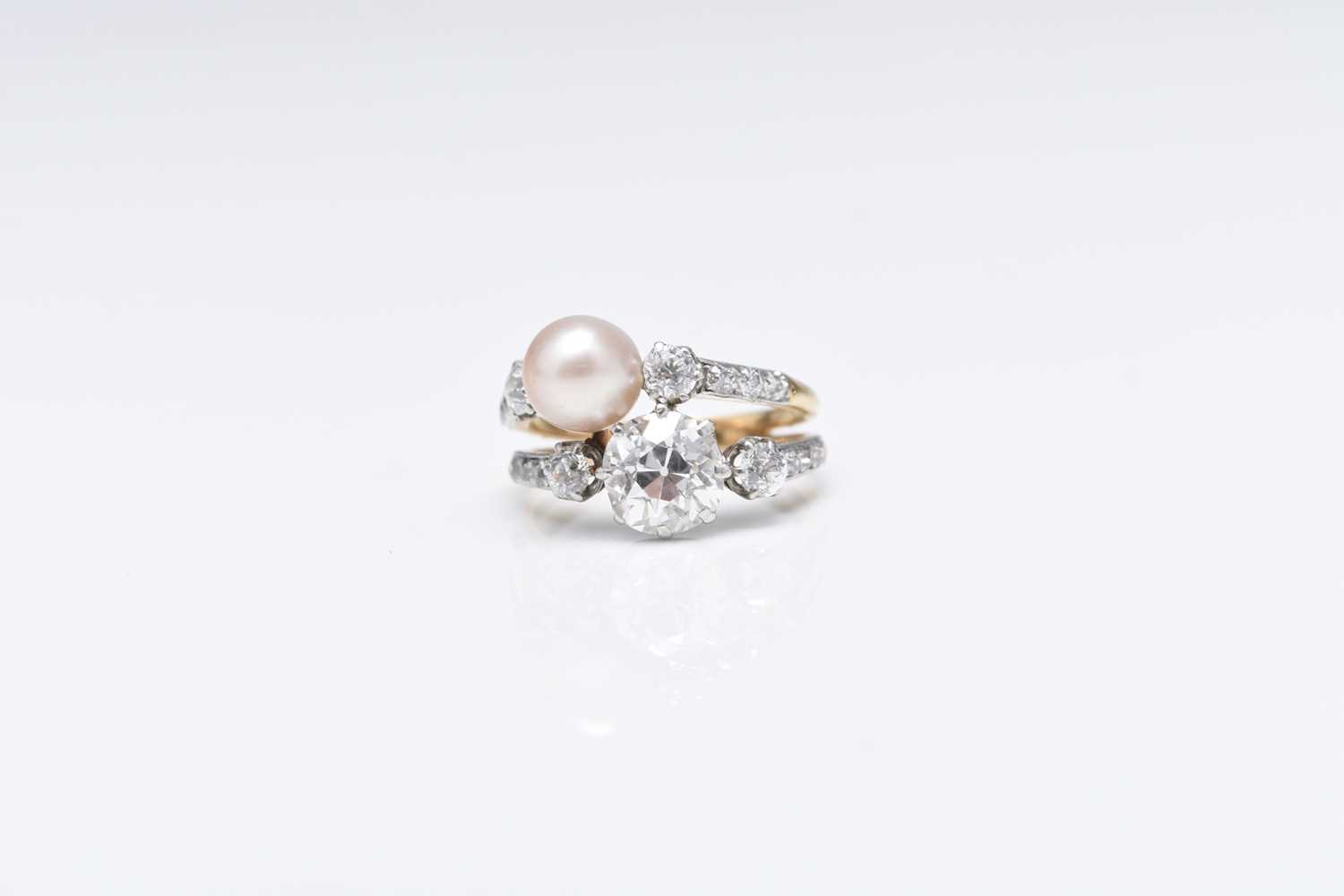 Lot 242 - An early 20th century diamond and pearl crossover ring