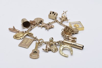 Lot 124 - A 9ct gold bracelet with attached charms