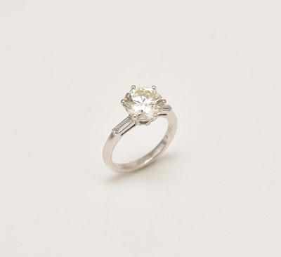 Lot 293 - An 18ct white gold single stone diamond ring with baguette cut diamond set shoulders