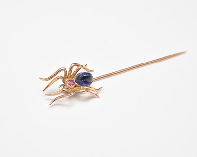 Lot 273 - A cabochon sapphire and ruby set stick pin in the form of a spider