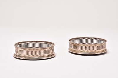 Lot 48 - A near pair of silver mounted wine coasters