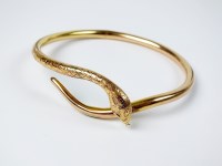 Lot 69 - A yellow metal hollow snake bangle, stamped...