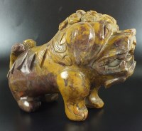 Lot 122 - A Chinese carved hard stone 'Fu' dog, in...