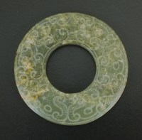 Lot 181 - A Chinese carved jade bi, in archaic style, of...