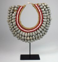 Lot 53 - A woven seed & shell necklace on stand from...