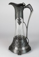 Lot 134 - An Art Nouveau pewter cased glass claret jug,...