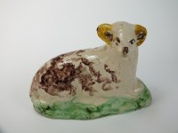 Lot 9 - A Staffordshire creamware model of a recumbent...