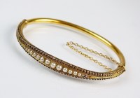 Lot 179 - A Victorian split pearl hinged bangle,...