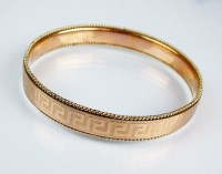 Lot 184 - A 9ct gold slave bangle, with stylised Greek...
