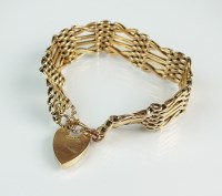 Lot 192 - A yellow metal gate link bracelet, the heart...