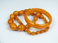 Lot 233 - A simulated amber coloured graduated necklace,...